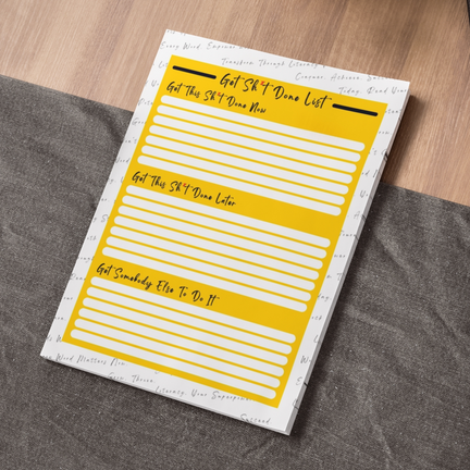a yellow note pad sitting on top of a table