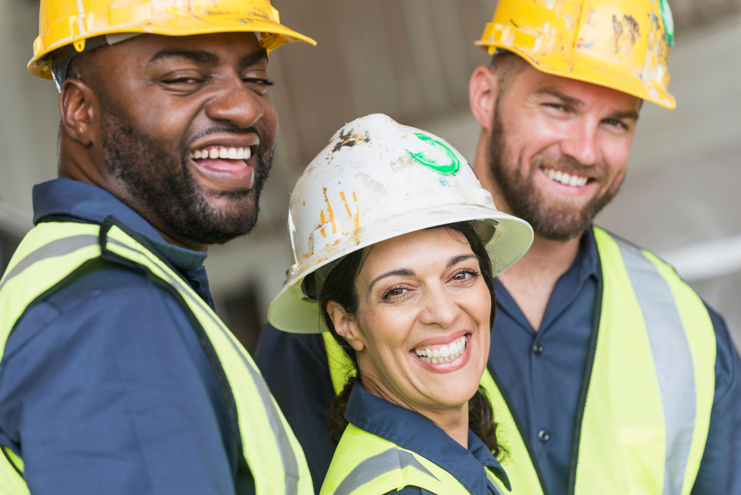 three construction workers smiling for the camera